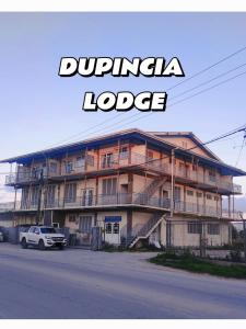 努库阿洛法Dupincia Lodge的一座大型建筑,前面停有一辆卡车