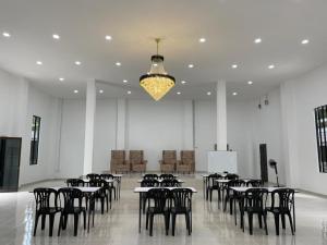 TumpatDGeting Beach Resort的大型客房配有桌椅和吊灯。