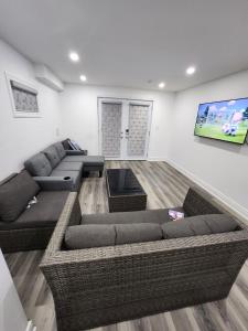 InnisfilNew Modern cozy room in Innisfil的客厅配有2张沙发和1台平面电视