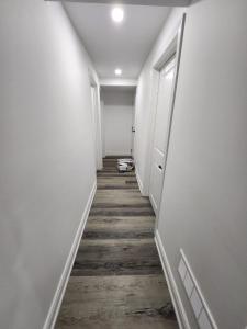 InnisfilNew Modern cozy room in Innisfil的走廊设有白色墙壁和木地板