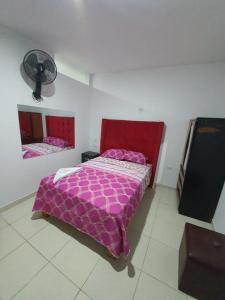 瓦乔HOSTAL GRAND IBIZA的卧室配有粉红色的床和风扇。