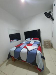 瓦乔HOSTAL GRAND IBIZA的一间卧室配有一张红色白色和蓝色棉被的床