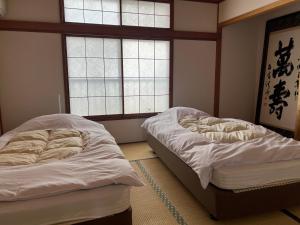 热海Marina Bay Atami的带2扇窗户的客房内的2张床