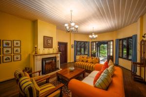 努沃勒埃利耶Ferncliff Bungalow的客厅配有橙色家具和壁炉
