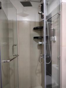 马尼拉Smdc Breeze Residence的带淋浴的浴室,带玻璃门