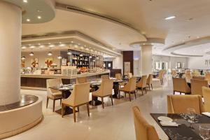 拉斯阿尔卡麦Al Hamra Residence的一间带桌椅的餐厅和一间酒吧