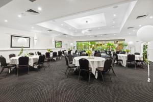 本迪戈本迪戈全季度假酒店的宴会厅配有白色桌子和黑色椅子