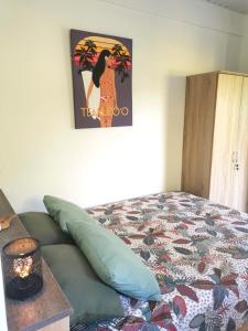 乌图罗阿Fare Kairos的卧室配有一张床,墙上挂着一幅画