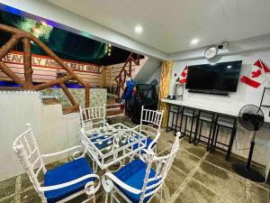 Santa Rosaaffordable 2 bedroom rest house w/ pools & parking的客厅配有椅子和平面电视