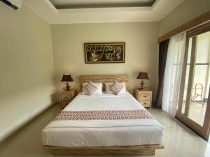 努沙杜瓦Green D'Mel Luxury Homestay的一间卧室配有一张带2个床头柜的大床