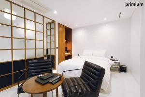 首尔艺术家驿三汽车旅馆的一间卧室配有一张床、两把椅子和一张桌子