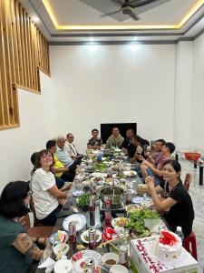 Lien SonLak village的一群人坐在长桌旁吃着食物