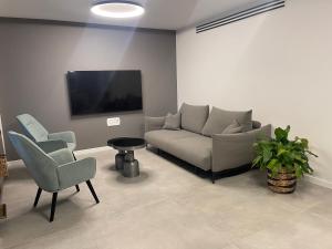 内坦亚Netanya-Appartement - 5p的客厅配有沙发、两把椅子和电视