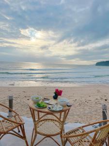 Phú Hạnh (5)Santa Fe House - Gành Đá Đĩa的海滩上的餐桌和食物