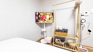 首尔New Corestay # Edae Stn 2min 2R 2F # near Hongdae的一间卧室配有一张床,墙上配有电视
