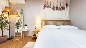 首尔New Corestay # Edae Stn 2min 2R 2F # near Hongdae的卧室配有白色的床和植物