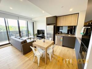 堪培拉Lavish in Lyneham - 2BD 1Bth Apt的厨房以及带桌子和沙发的客厅。