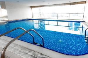迪拜Citi home 1BR New Marina Sulafa Tower的大楼内一个蓝色的大型游泳池