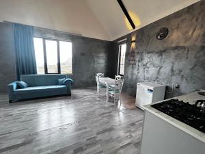 库萨雷Shahdag Mountain House的一间带蓝色沙发的客厅和一间厨房