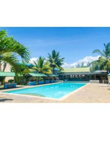 乌昆达ASINS HOLIDAY INN HOTEL的一座棕榈树游泳池和一座建筑