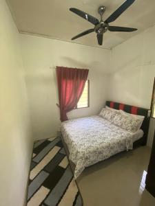 彭亨Chu Mon's Homestay Janda Baik (15 min from river)的一间卧室配有一张床和吊扇