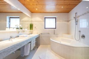 巴德小基希海姆瓦索洛住宿加早餐公寓酒店的白色的浴室设有浴缸和水槽。