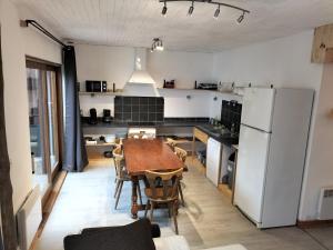 瓦卢伊斯A découvrir Superbe Maison Calme et Lumineuse的厨房配有桌子和白色冰箱。