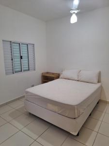 瓜鲁雅Recanto do Sossego的一间白色卧室,卧室内配有一张床