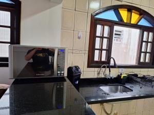 瓜鲁雅Recanto do Sossego的厨房柜台上的微波炉,里面的人