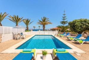 阿雷纳尔登卡斯特尔Villa Mar Azul的一个带躺椅的游泳池和一个游泳池