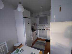 拉彭兰塔Viihtyisä kaksio ydinkeskustassa的白色的厨房配有桌子和冰箱