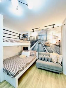 塔里萨伊Antara-QueenBed-Balcony-HotShower-WorkCoffee Station-FullKitchen的客房设有两张双层床和一张沙发。