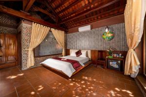 宁平Tam Coc Ngoc Linh Bungalow Ninh Bình的一间带一张床的卧室,位于带木制天花板的房间内