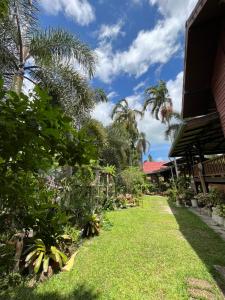 达叻府ครูหนูบ้านพัก แหลมงอบ Krunou baanpak的棕榈树屋前的花园