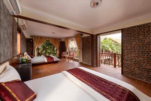 宁平Tam Coc Ngoc Linh Bungalow Ninh Bình的一间带两张床的卧室和一个阳台