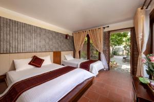 宁平Tam Coc Ngoc Linh Bungalow Ninh Bình的一间带两张床的卧室和一个阳台
