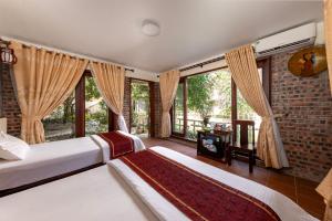 宁平Tam Coc Ngoc Linh Bungalow Ninh Bình的卧室设有两张床,配有大窗户