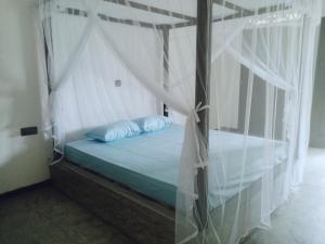 希克杜沃Villa Conch by Om - Private House - Hikkaduwa的卧室配有带白色窗帘的天蓬床