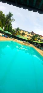 乌昆达ASINS HOLIDAY INN HOTEL的一座种植了棕榈树的蓝色游泳池