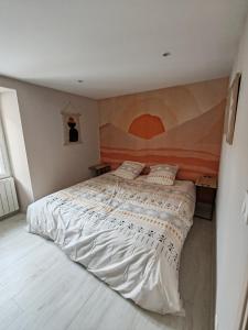 昂古莱姆LaMaisonnette_au_36的卧室配有一张大床,墙上挂有绘画作品