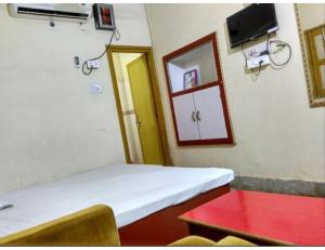 加雅Shivam Guest House, Gaya的客房设有床、桌子和窗户。