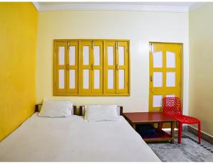 加雅Shivam Guest House, Gaya的卧室配有1张床、1张桌子和1把椅子