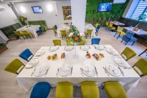 布加勒斯特科维沃斯酒店的一间配备有白色桌椅的用餐室