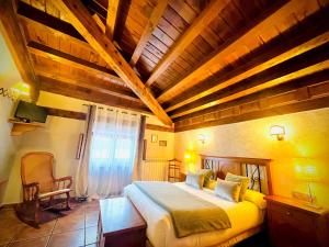 CasarejosPosada Real de Carreteros的一间卧室设有一张带木制天花板的大床