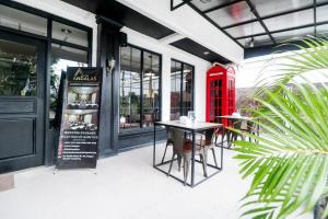班达楠榜RedDoorz Plus @ Jalan Raden Intan Lampung的红色电话亭和餐厅外的桌子
