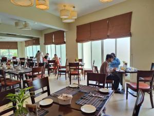 巴里沙尔Hotel Grand Park Barishal的一间设有桌子的餐厅,有坐在桌子上的人