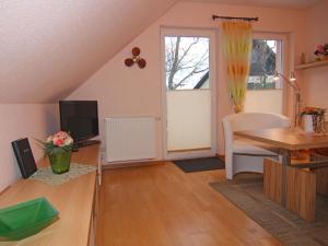 奥茨塞巴德·迪尔哈根Apartment in Dierhagen with balcony的客厅配有桌子和书桌及电视