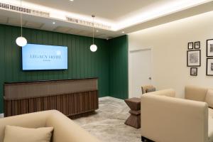 曼谷Legacy Hotel Bangkok Sukhumvit的图书馆时,一间配有平面电视的等候室