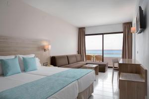 滨海罗克塔斯Alua Golf Trinidad的酒店客房设有一张床,享有海景。