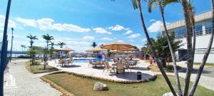 巴西利亚Luxuoso Flat em resort vista incrível para o Lago的一个带游泳池和桌椅的度假酒店